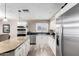 Bright kitchen features an island with granite countertops, stainless steel appliances, and white cabinetry at 2001 W Surrey Ave, Phoenix, AZ 85029
