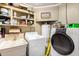 Laundry room featuring a sink, washer, dryer, and built-in shelving at 2001 W Surrey Ave, Phoenix, AZ 85029