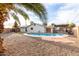 Backyard pool surrounded by gravel, palms and patio, perfect for entertaining and outdoor living at 2001 W Surrey Ave, Phoenix, AZ 85029