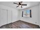 Bedroom with hardwood floors, closet, ceiling fan and window with exterior view at 2024 N 200Th Ave, Buckeye, AZ 85396