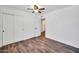 Bright bedroom with hardwood floors, ceiling fan, and convenient closet and ensuite bathroom access at 2024 N 200Th Ave, Buckeye, AZ 85396