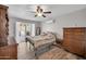 Bedroom with wood floors, air conditioner, ceiling fan and dresser, leading to outdoor patio through doors at 2024 N 200Th Ave, Buckeye, AZ 85396