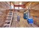 Rustic interior featuring wood paneling, a ladder leading to a loft, and unique storage options at 2024 N 200Th Ave, Buckeye, AZ 85396