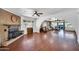 Spacious living room with a brick fireplace, wood flooring and multiple seating areas at 2024 N 200Th Ave, Buckeye, AZ 85396