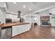 Spacious open floor plan with kitchen and living room featuring a brick fireplace and wood floors at 2024 N 200Th Ave, Buckeye, AZ 85396