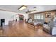 Spacious living room with a brick fireplace, wood flooring and multiple seating areas at 2024 N 200Th Ave, Buckeye, AZ 85396