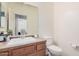 Powder room featuring a light wood vanity with single sink, light walls, and toilet at 20261 W Desert Bloom St, Buckeye, AZ 85326