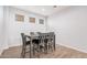Contemporary dining area with a dark wood table, seating for six and wood-look flooring at 20261 W Desert Bloom St, Buckeye, AZ 85326