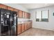 Bright kitchen featuring wood cabinets, granite counters, black appliances, and wood floors at 20261 W Desert Bloom St, Buckeye, AZ 85326