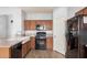 Bright kitchen featuring wood cabinets, granite counters, black appliances, and wood floors at 20261 W Desert Bloom St, Buckeye, AZ 85326
