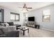 Comfortable living room featuring a plush sofa, herringbone floors, and lots of natural light at 20261 W Desert Bloom St, Buckeye, AZ 85326