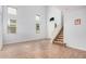 Light-filled living area with wood-look tile flooring, high ceilings, and staircase access at 20261 W Desert Bloom St, Buckeye, AZ 85326