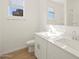 Bathroom with double sinks, white cabinets, and ample natural light at 20368 N 224Th Dr, Surprise, AZ 85387