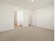 Spacious bedroom with carpet, neutral paint, and open access to the bathroom and walk-in closet at 20368 N 224Th Dr, Surprise, AZ 85387