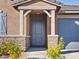 Inviting entryway with stone accents, a covered porch, and a modern, stylish front door at 20368 N 224Th Dr, Surprise, AZ 85387