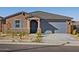Charming single-story home featuring desert landscaping, blue accents, and a two-car garage at 20368 N 224Th Dr, Surprise, AZ 85387