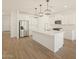 Open kitchen with a large island, stainless steel appliances, and modern, white cabinetry throughout at 20368 N 224Th Dr, Surprise, AZ 85387