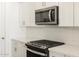 Modern kitchen featuring stainless steel appliances, white cabinetry, and a sleek microwave at 20368 N 224Th Dr, Surprise, AZ 85387