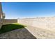 Well-maintained backyard with artificial grass, pavers, and a block fence at 21690 N Lynn St, Maricopa, AZ 85138