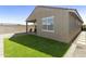 Landscaped backyard featuring artificial turf, pavers, and covered patio area at 21690 N Lynn St, Maricopa, AZ 85138