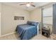 This cozy bedroom features carpet, a ceiling fan, and a comfortable blue bed at 21690 N Lynn St, Maricopa, AZ 85138