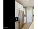 Modern kitchen featuring stainless steel refrigerator, white cabinetry, and sleek countertops at 21690 N Lynn St, Maricopa, AZ 85138