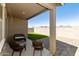 Cozy covered patio with seating overlooking the artificial grass backyard at 21690 N Lynn St, Maricopa, AZ 85138