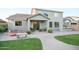 A beautifully landscaped backyard includes a brick-paved patio, seating areas, lush lawn and outdoor kitchen with BBQ at 2211 W Desert Ln, Phoenix, AZ 85041