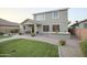 The well-kept backyard has a built-in BBQ kitchen, seating, brick patio, and a plush green lawn for relaxation at 2211 W Desert Ln, Phoenix, AZ 85041