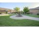 View of the backyard showing the grass, brick-paved walkways, a fountain, and landscaping at 2211 W Desert Ln, Phoenix, AZ 85041