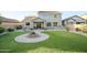 Large backyard features a well-manicured lawn, mature landscaping, brick patio, and water feature at 2211 W Desert Ln, Phoenix, AZ 85041