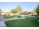 View of the backyard showing the grass, brick-paved walkways, a fountain, and landscaping at 2211 W Desert Ln, Phoenix, AZ 85041