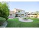Spacious backyard with lush lawn, mature trees, water feature, covered patio, and ample seating at 2211 W Desert Ln, Phoenix, AZ 85041