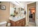 Bathroom with a wood vanity, white countertop, framed mirror, and views to the bedroom at 2211 W Desert Ln, Phoenix, AZ 85041