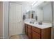 Bathroom with a vanity, large mirror, a door, neutral paint and flooring, and great lighting at 2211 W Desert Ln, Phoenix, AZ 85041