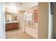 Bathroom boasts a soaking tub, a separate glass enclosed shower, and a vanity with a sink and mirror at 2211 W Desert Ln, Phoenix, AZ 85041
