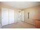A bedroom featuring carpeting, mirrored closet doors, and neutral paint at 2211 W Desert Ln, Phoenix, AZ 85041