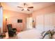 Cozy bedroom with light walls, a ceiling fan, and a dresser with a TV at 2211 W Desert Ln, Phoenix, AZ 85041