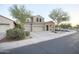 Two-story home with a three-car garage and a covered porch, featuring desert landscaping in the front yard at 2211 W Desert Ln, Phoenix, AZ 85041