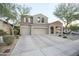 Home features a three-car garage, low-maintenance desert landscaping, covered porch, and tile roof at 2211 W Desert Ln, Phoenix, AZ 85041