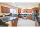 Updated kitchen features stainless steel appliances, granite counters, island, and wood cabinets at 2211 W Desert Ln, Phoenix, AZ 85041