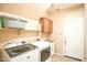 Bright laundry room featuring a modern washer and dryer, utility sink, and ample storage at 2211 W Desert Ln, Phoenix, AZ 85041