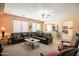 Spacious living room with an open view to the kitchen through an archway and large brown leather sectional at 2211 W Desert Ln, Phoenix, AZ 85041