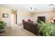 Comfortable living room featuring neutral walls, a large brown sofa and a ceiling fan at 2211 W Desert Ln, Phoenix, AZ 85041