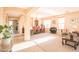Open-concept living and dining area with neutral tones, arched doorways, and tile/carpet flooring at 2211 W Desert Ln, Phoenix, AZ 85041