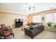 Inviting living room featuring a comfortable brown sectional sofa and two red chairs at 2211 W Desert Ln, Phoenix, AZ 85041