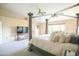 Bedroom with a canopy bed, carpeting, tan walls, and a door and doorway that leads into other rooms at 2211 W Desert Ln, Phoenix, AZ 85041