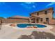 This backyard features a two-story home, block fencing, a pool, and mature landscaping at 22123 E Vía Del Palo --, Queen Creek, AZ 85142