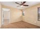 This bedroom has neutral carpet, a ceiling fan, access to an ensuite bathroom, and natural light at 22123 E Vía Del Palo --, Queen Creek, AZ 85142