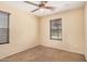 This bedroom features neutral carpet, a ceiling fan, and a window with wood-look blinds at 22123 E Vía Del Palo --, Queen Creek, AZ 85142